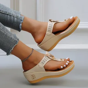 Close-up of beige wedge thong sandals with rhinestone detail and hollow-out strap