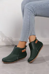 Stilvolle flache dunkelgrüne Stiefeletten für Damen mit Klettverschluss am Modell getragen