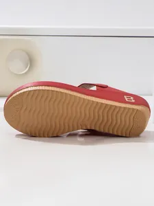 Detail of red platform sandals showing wave-patterned non-slip sole and side metal B logo.