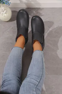 Detailansicht der schwarzen flachen Damen-Stiefeletten mit weißen Kontrastnähten
