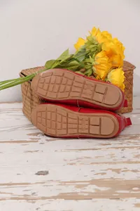 Detailaufnahme der rutschfesten Gummisohlen roter Lackleder-Slipper mit Größenmarkierung