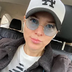 Vintage octagonal metal sunglasses worn by model in a realistic car lifestyle setting