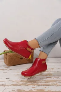 Detailansicht rote flache Stiefeletten mit Klettverschluss getragen zu Jeanshosen