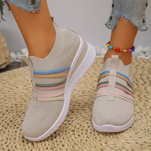 Nahaufnahme von atmungsaktiven Fly-Woven-Keilsneakern für Damen mit bunten Gummibändern.