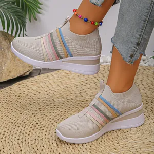 Detaillierte Nahaufnahme der atmungsaktiven beigen Keilsneaker aus Fly-Knit mit bunten Streifen