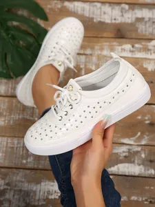 Close-up of white breathable slip-on sneakers with elegant laser-cut patterns