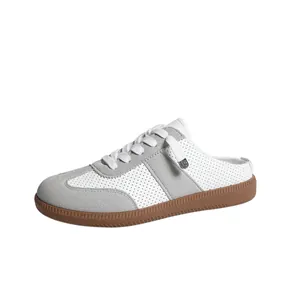 Gedetailleerd zijaanzicht van klassieke geperforeerde dames instapsneakers in wit en grijs.