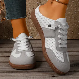 Gedetailleerde weergave van retro grijze en witte geperforeerde casual sneakers voor dames