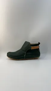 Seitliche Detailansicht einer dunkelgrünen Kunstleder-Stiefelette mit braunem Klettband