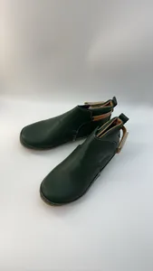 Detaillierte Seitenansicht dunkelgrüner Lederstiefeletten mit Klettverschluss-Riemen