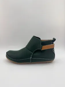 Seitenansicht dunkelgrüner Damen-Stiefeletten mit weißen Kontrastnähten und Klettverschluss.