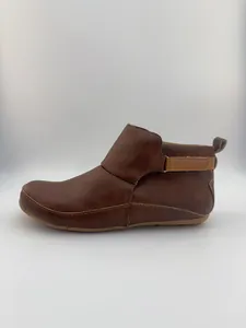 Seitenansicht brauner flacher Damenstiefeletten mit modischem Riemen und feiner Naht