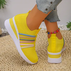 Nahaufnahme gelber Strick-Sneaker mit bunten Akzenten und Details der Keilsohle