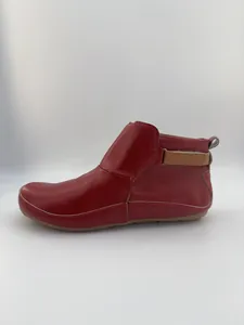 Seitenansicht der roten flachen Stiefelette mit braunem Klettverschluss-Detail.