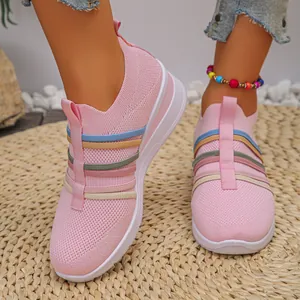 Nahaufnahme von rosa Flyknit-Sneakern mit bunten Riemen und weißer Keilsohle.