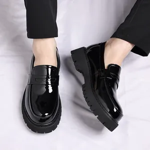 Detailopname van glanzende zwarte lakleren platform loafers met dikke profielzolen