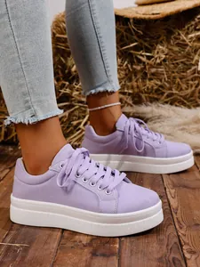 Detalle de zapatillas de plataforma de lona para mujer en lila con suelas blancas gruesas