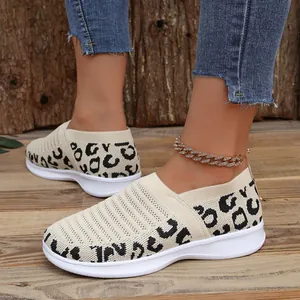 Close-up van beige gebreide instapsneakers voor dames met luipaardprint aan de voeten
