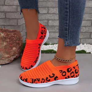 Detailopname van feloranje ademende fly-knit sneakers voor dames met luipaardprint