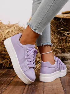 Primer plano de zapatillas de plataforma de lona violeta con cordones y suela blanca gruesa
