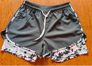 Detail view of women's double-layer sports shorts with pink pixel camo inner lining