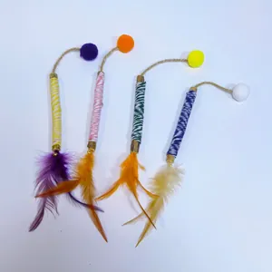 Macro detail of Matatabi cat chewing sticks featuring colorful feathers and plush balls