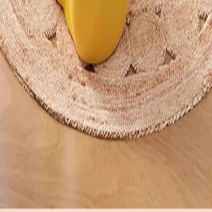 Detailed macro view of the circular woven mat and yellow base of the whale feeder toy.