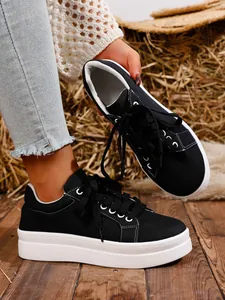 Detalle de la textura de lona negra y la suela de plataforma blanca gruesa en el zapato de mujer.