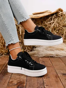 Zapatillas de plataforma en lona negra con costuras en contraste puestas en modelo
