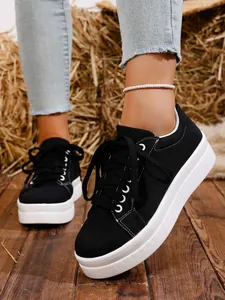 Detalle que muestra la textura y construcción de zapatillas de lona negra para mujer.
