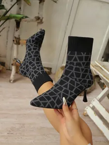 Nahaufnahme von gestrickten Socken-Stiefeletten mit geometrischem Muster und Stiletto-Absatz.