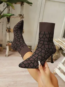 Detailaufnahme brauner Strickstiefel mit Pfennigabsatz und elegantem geometrischem Muster