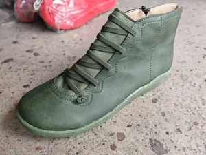 Close-up view of vintage dark green casual flat ankle boot with elastic laces and zipper