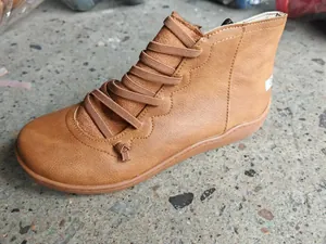 Detail shot of brown vintage flat ankle boot for women with stylish stitching