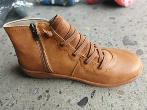 Close-up detail of vintage brown women's flat short boots with side zipper and laces