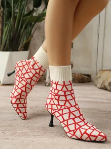 Detail der rot-weißen geometrischen Strick-Sockenstiefel mit spitzer Kappe und Absatz
