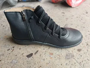 Detailed side view of vintage black flat ankle boots with side zipper and straps