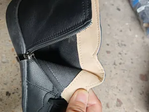 Macro detail showing the durable metal zipper and soft interior lining of a black leather boot