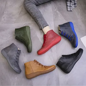 Vintage flat ankle boots for women in multiple colors on a grey stone background