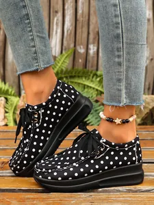 Λεπτομερής προβολή των casual sneakers με πλατφόρμα, μαύρο και άσπρο πουά με κορδόνια