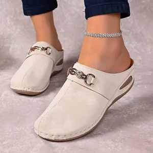 Comfortable beige slip-on mules for women with gold chain decor and side cutout details