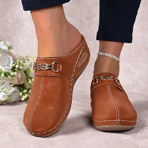 Casual brown women's clogs featuring gold buckle and decorative white stitching