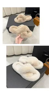 Gros plan de chaussons croisés en peluche beige et crème avec des semelles épaisses