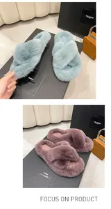 Détail de chaussons en fausse fourrure à brides croisées en bleu et en violet