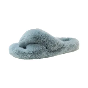 Pantoufles en fausse fourrure bleu clair avec brides croisées et semelle épaisse.