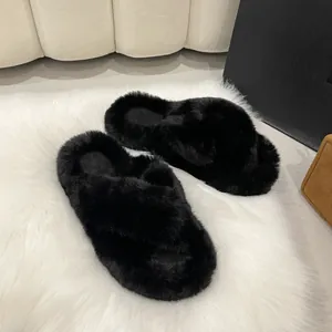 Chaussons noirs en fourrure à brides croisées pour femmes sur tapis blanc moelleux