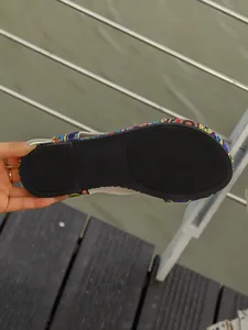Detailed view showing the black anti-slip rubber sole of ethnic floral flat sandals
