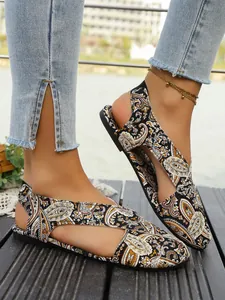 Close-up of ethnic style flat sandals with intricate paisley print and closed-toe.