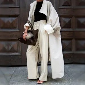 Detailed view of a stylish oversized light apricot trench coat featuring a premium satin lining