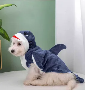 Close-up of a small dog wearing a plush blue shark-themed costume for pets